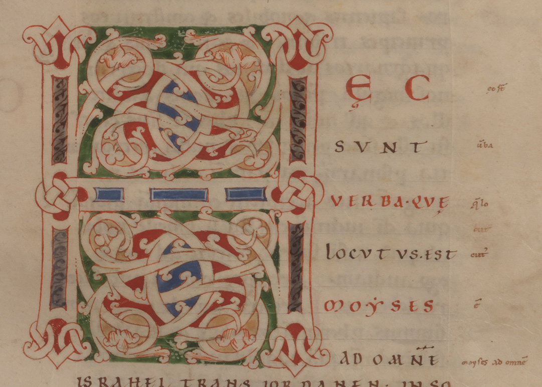 Initial with scrolls defined in a geometric shape.